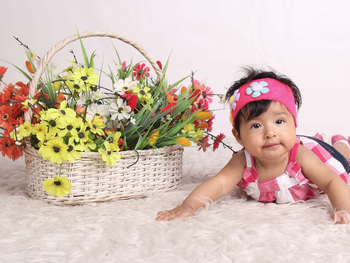 Маленькая девочка рядом с корзиной цветов 