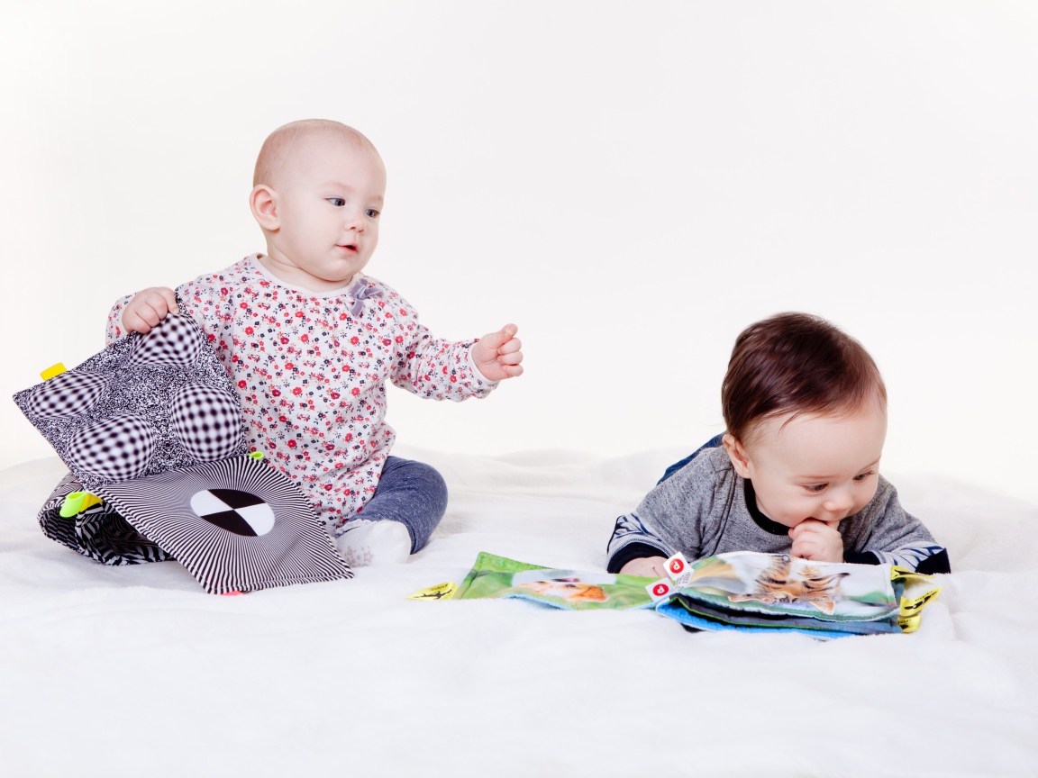 Two little children playing on a white background