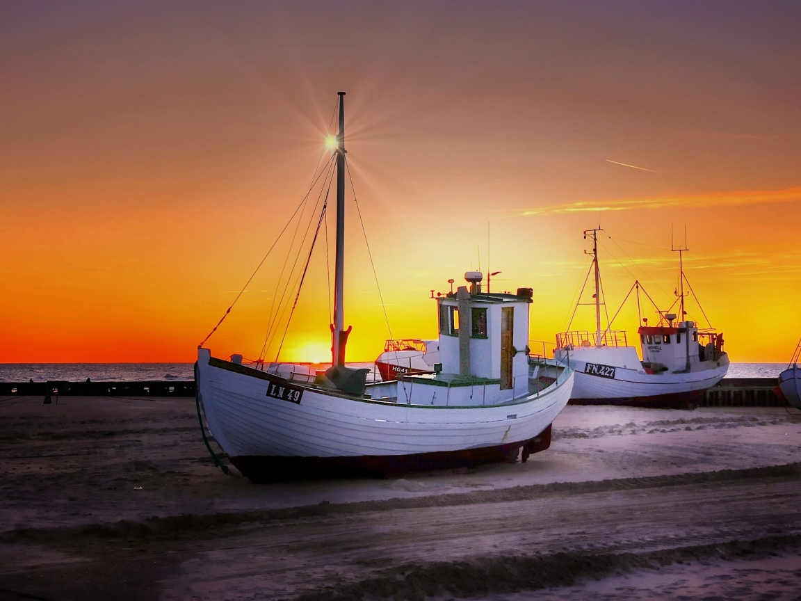 Рыбацкая лодка на берегу на закате 