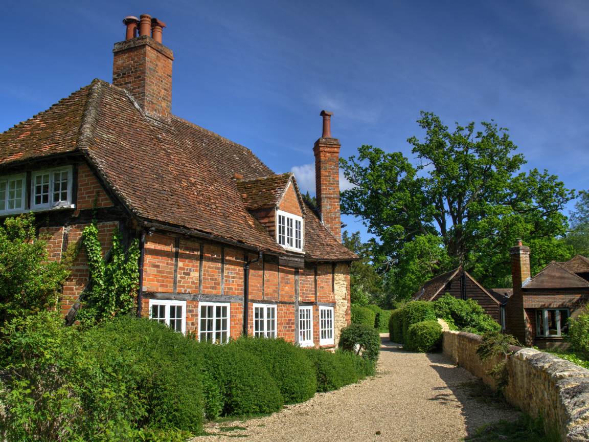 Кирпичный старый дом под голубым небом, Англия 