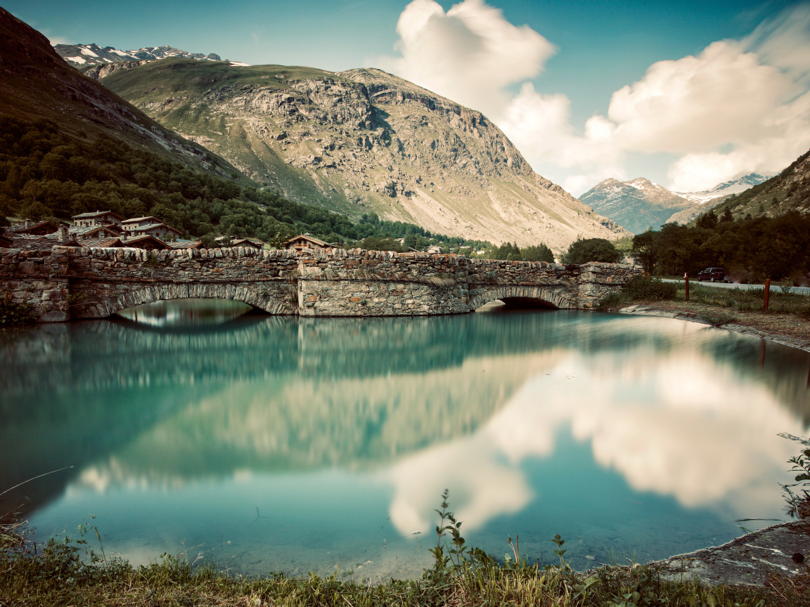 Старый кирпичный мост на озере у горы,Франция