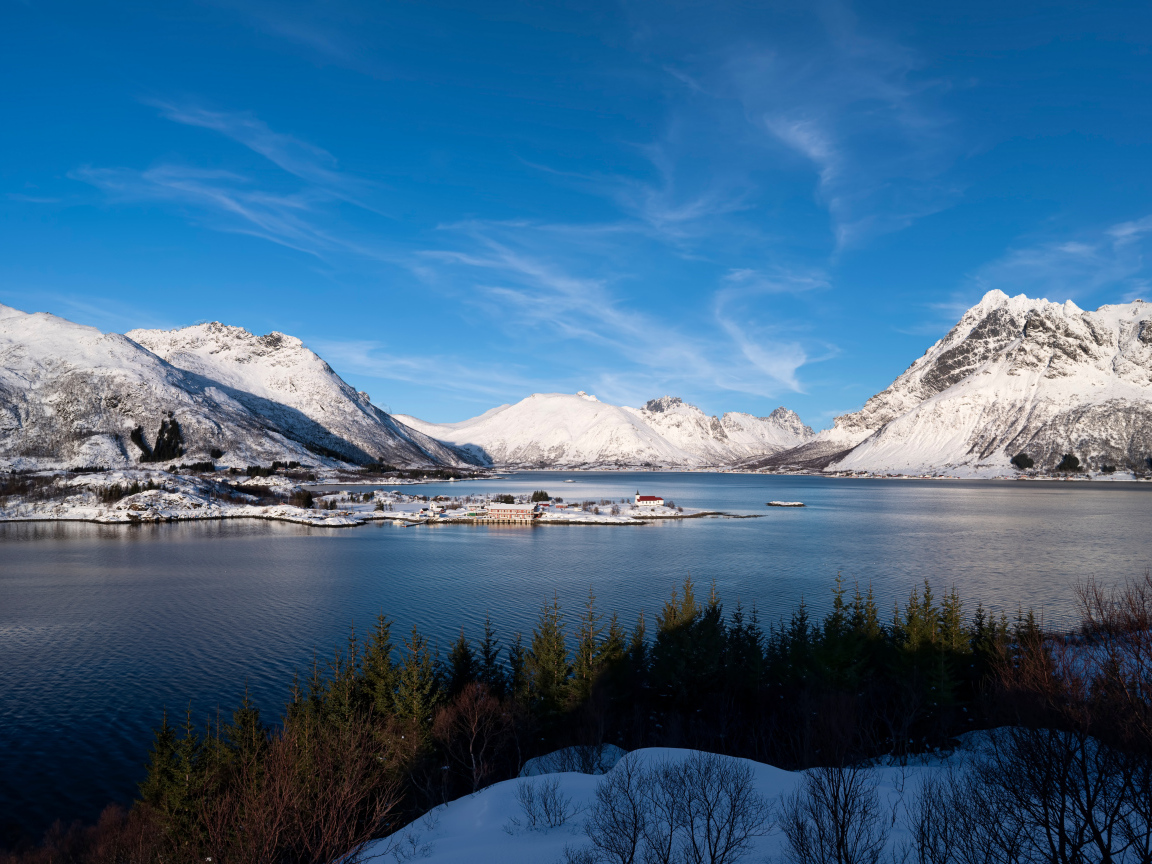 Покрытые снегом горы под голубым небом у воды, Норвегия