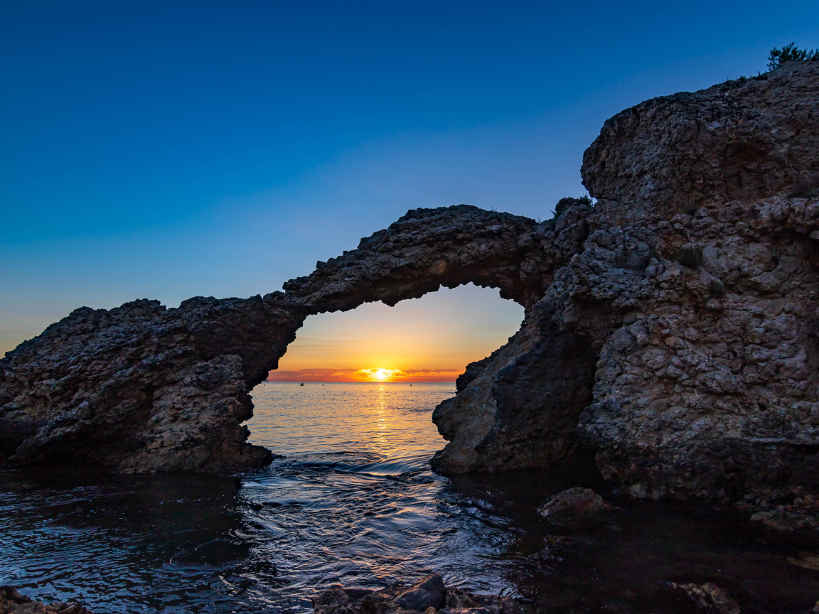 Арка в скале на закате, Испания