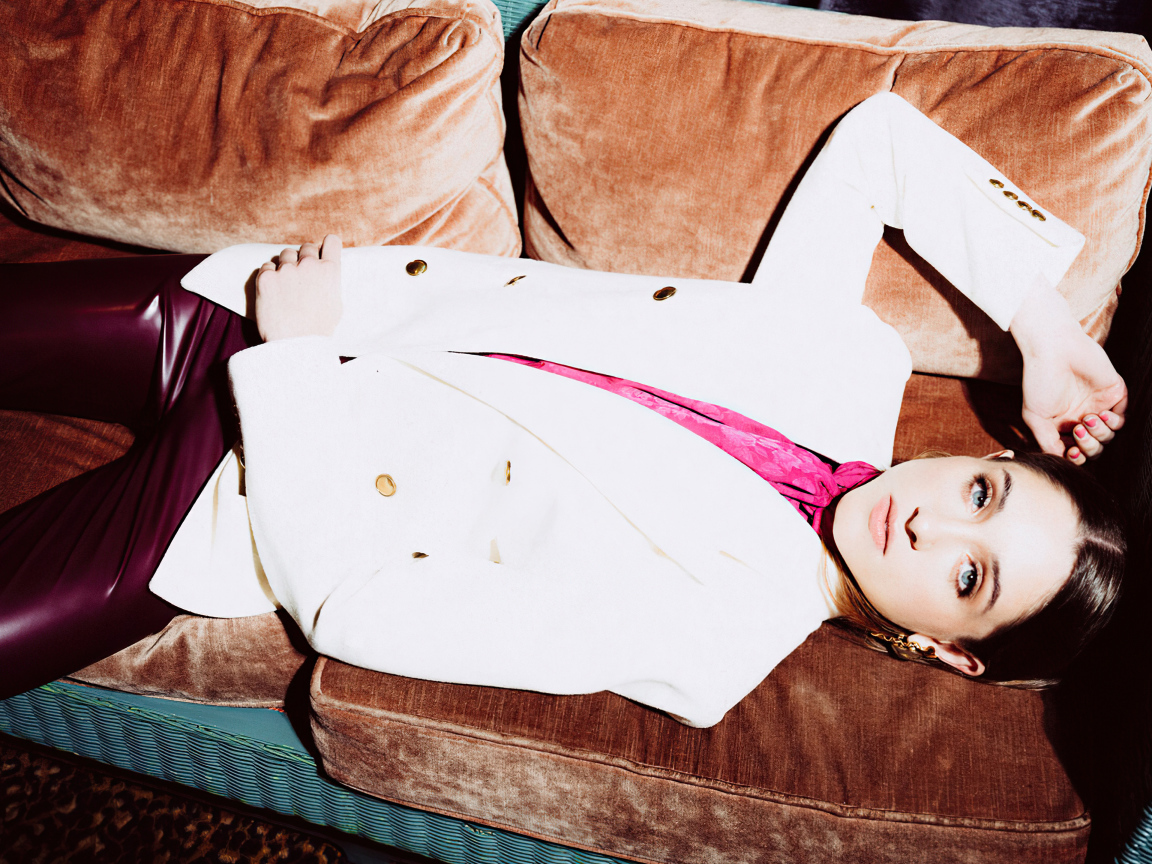 Актриса Наталия Дайер лежит на диване