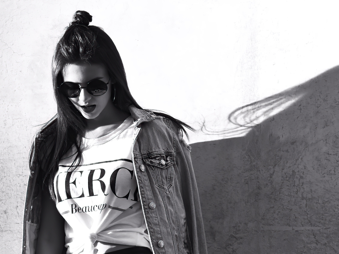 Актриса  Виктория Джастис в очках у стены