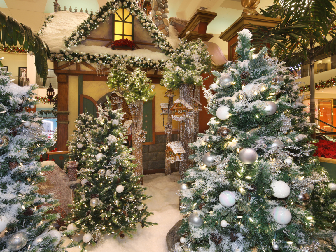 Новогодние ели стоят в комнате с декором 