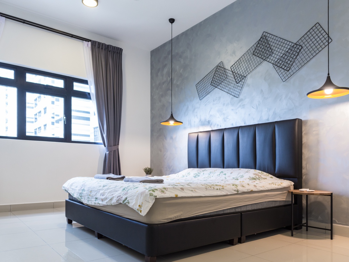 Пустая спальная комната с большой кроватью у окна 