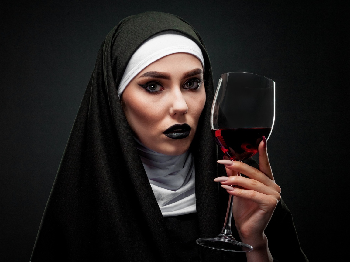 Девушка в костюме монашки с бокалом в руке