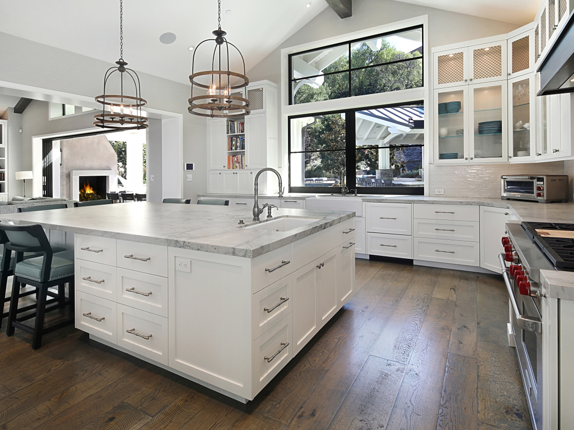 Большой гранитный стол в кухне с белой мебелью 