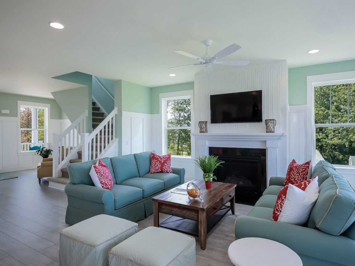 Большая гостиная комната с камином и лестницей на верх 