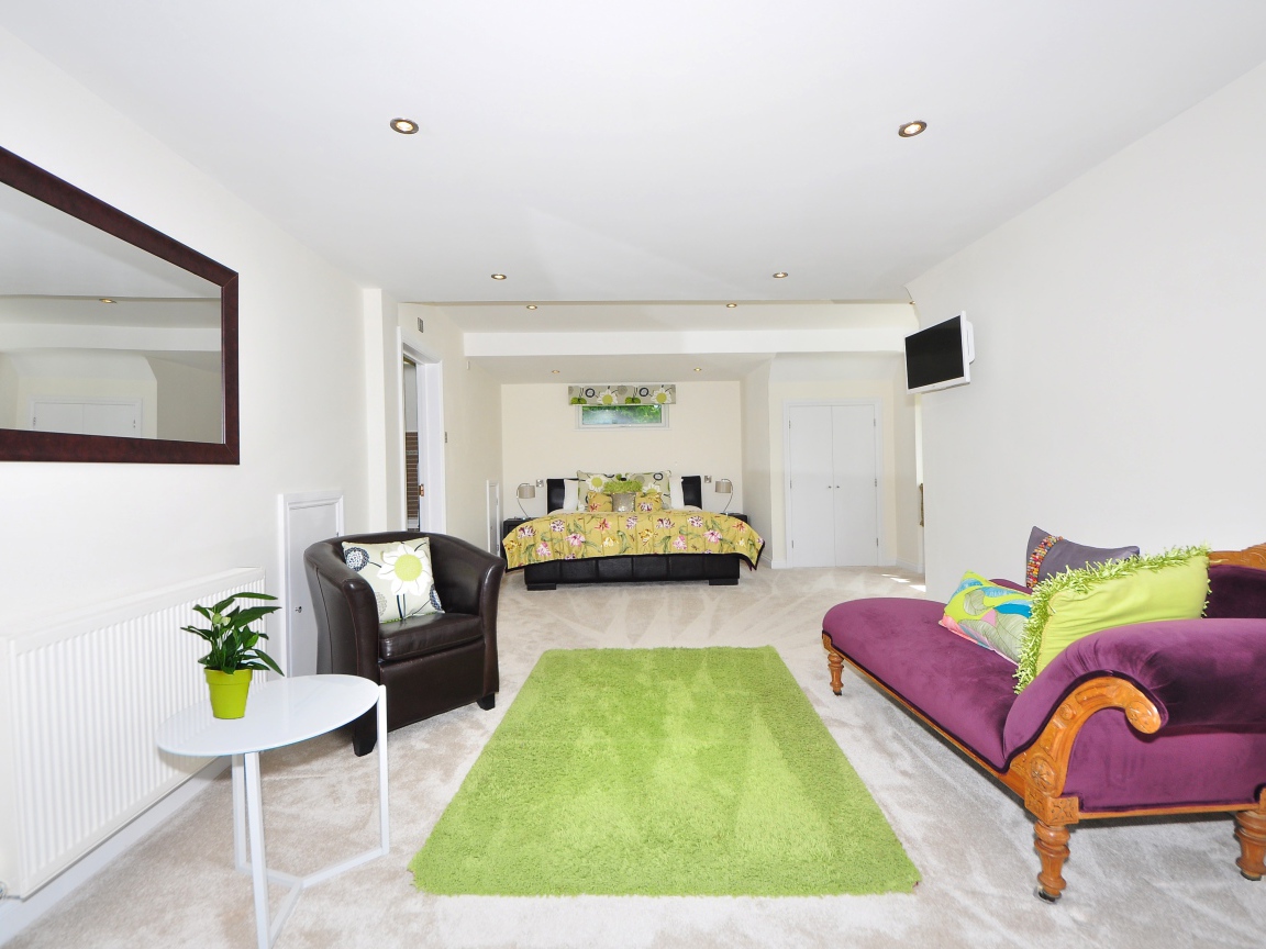 Большая гостиная с высокими белыми стенами и мебелью 