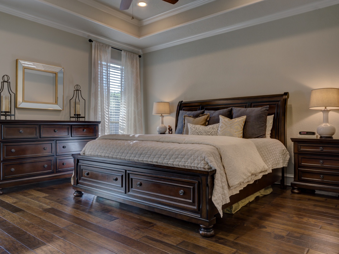 Большая деревянная кровать в спальной комнате 