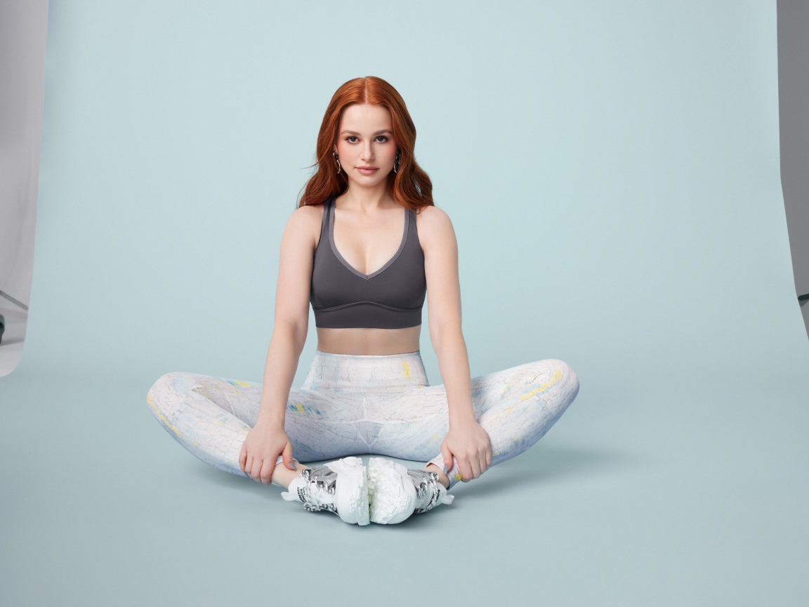 Рыжеволосая американская актриса Мэделин Петш сидит в позе лотоса