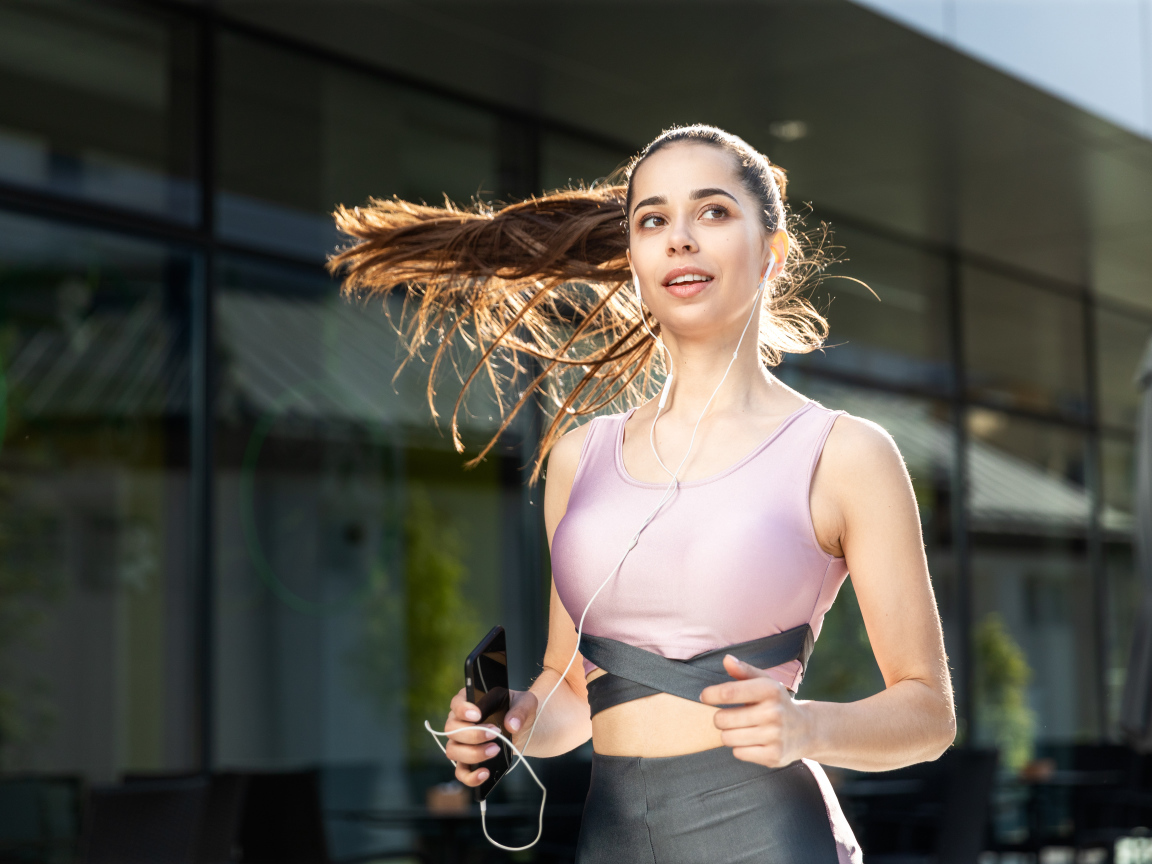 Спортивная девушка занимается бегом на улице