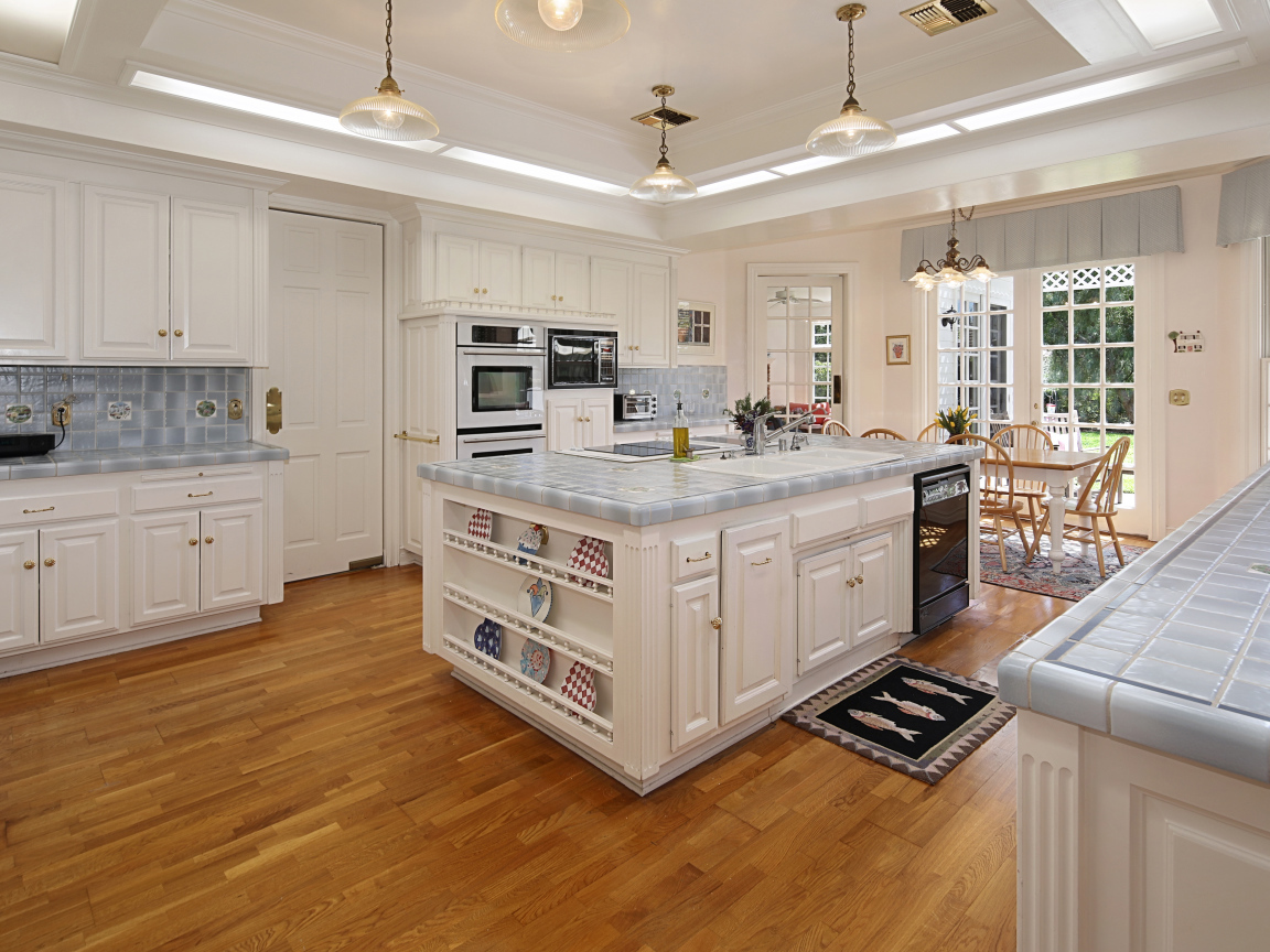 Белые стены и мебель на просторной современной кухне 