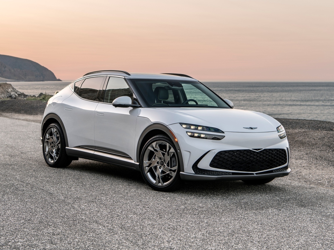 Белый автомобиль Genesis GV60, 2023 года на пляже