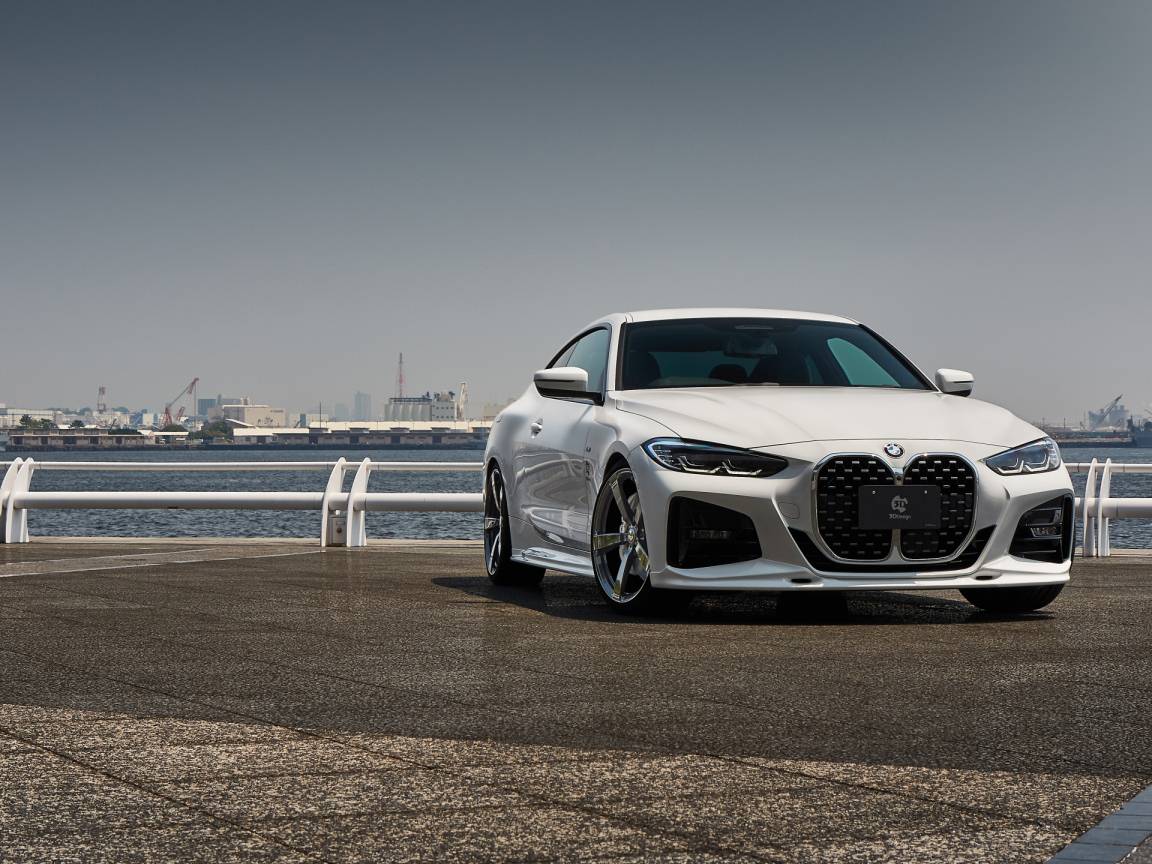 Белый автомобиль BMW 4 Series Coupé M Sport Package 2021  года у моря