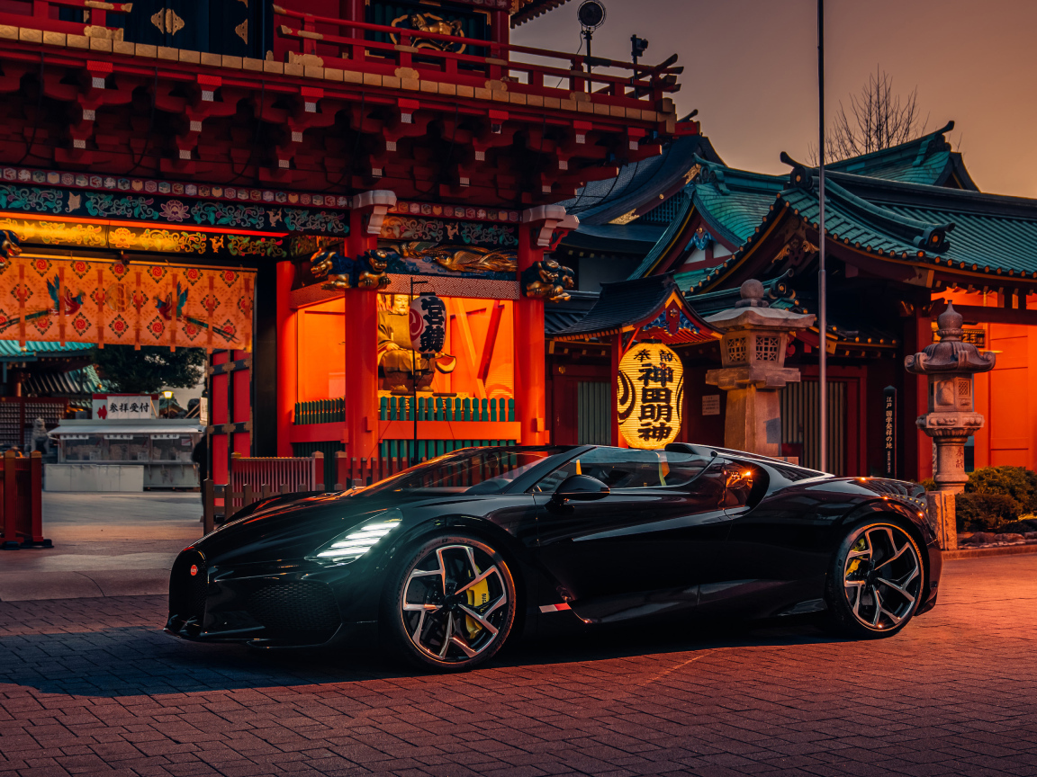 Черный спортивный автомобиль Bugatti W16 Mistral  у здания