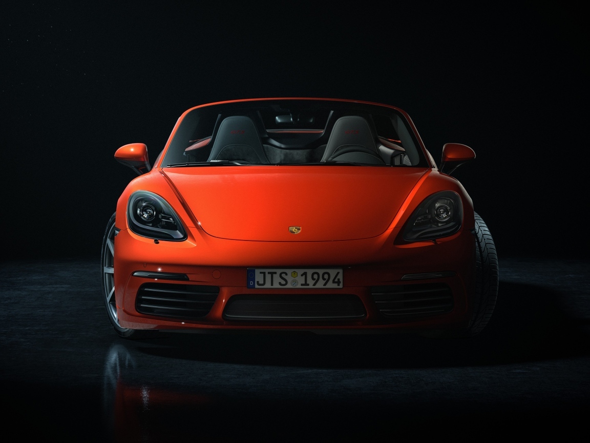 Красный автомобиль Porsche 911 CGI  вид спереди на черном фоне