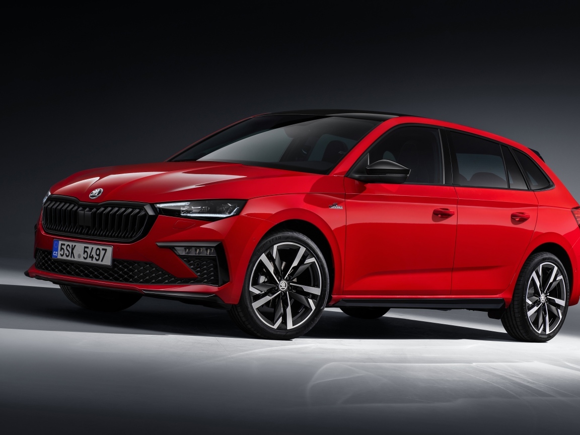 Красный автомобиль Skoda Scala Monte Carlo 2023 года на сером фоне