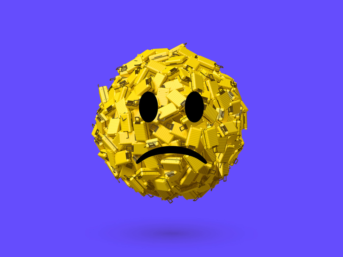 Грустный смайлик из чемоданов на синем фоне