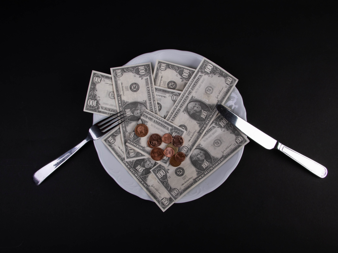 Тарелка с долларами на черном фоне