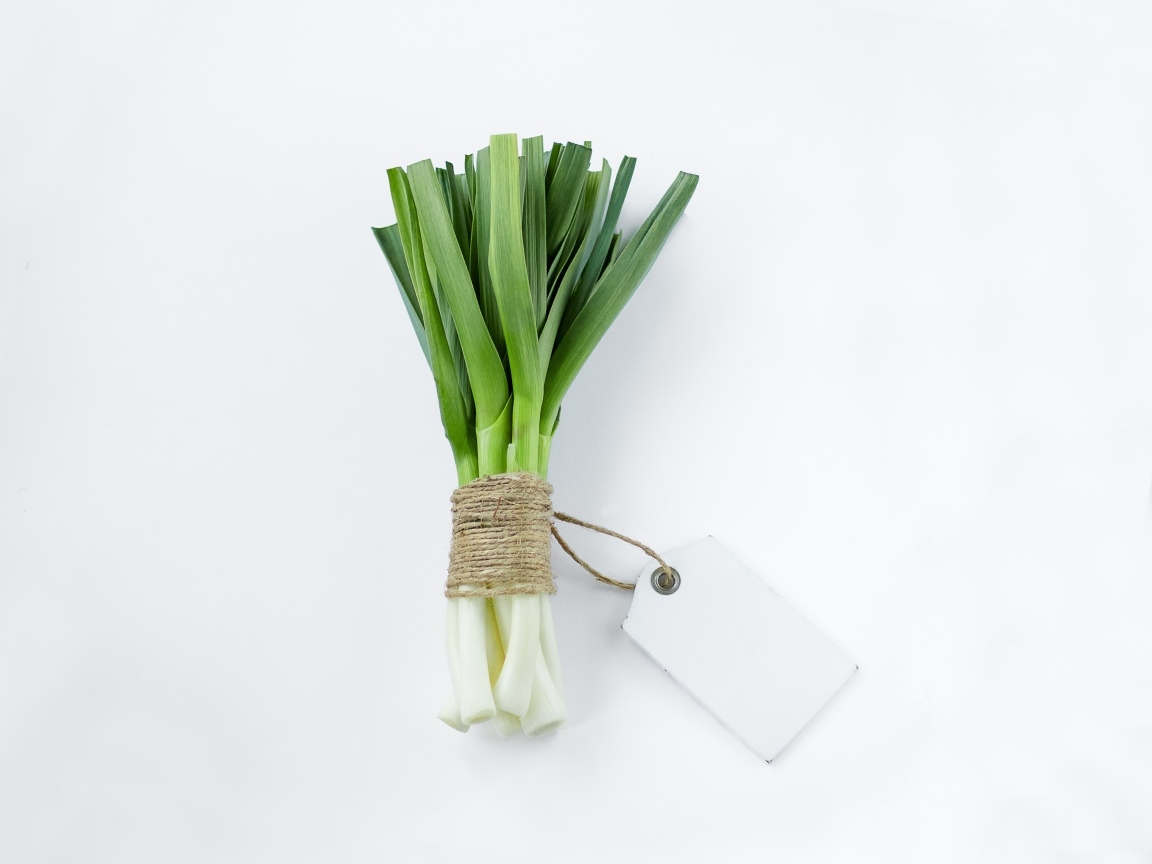 Пучок зеленого лука на белом фоне