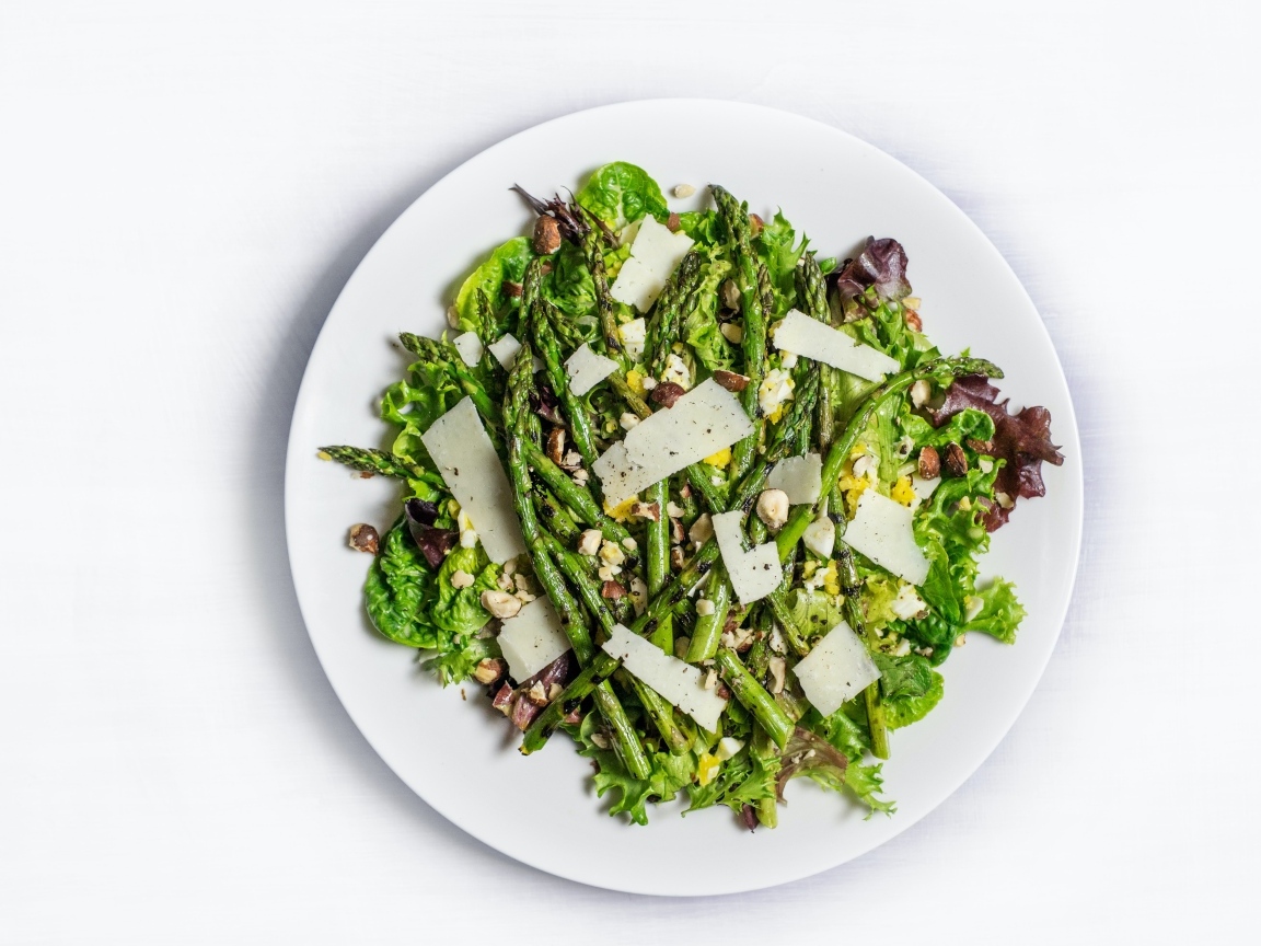 Спаржа на белой тарелке с сыром