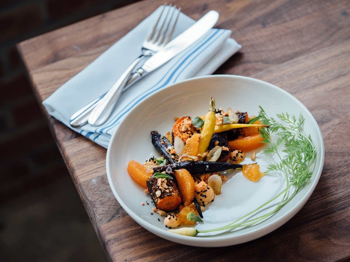 Жареные овощи на тарелке со столовыми приборами