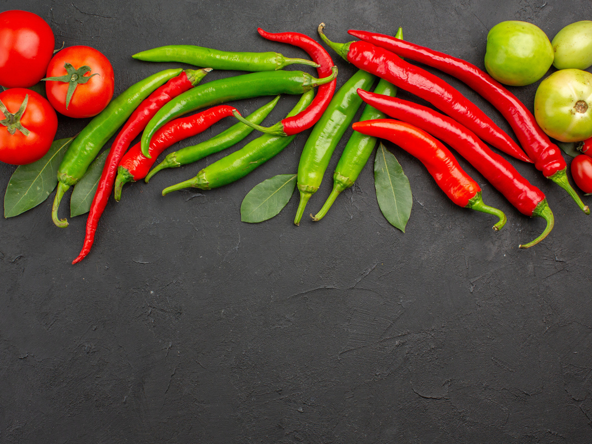 Острый перец чили на столе с помидорами