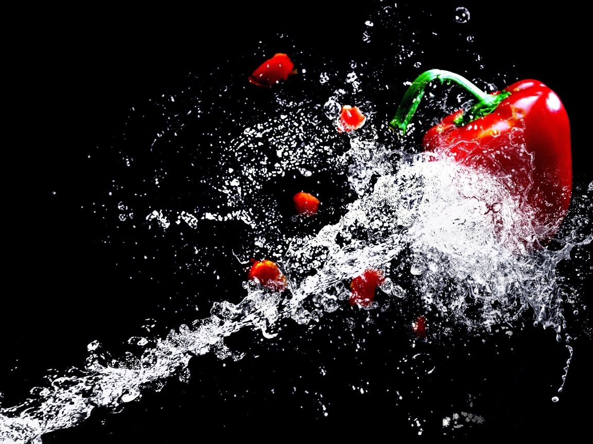 Сладкий красный перец в брызгах воды на черном фоне