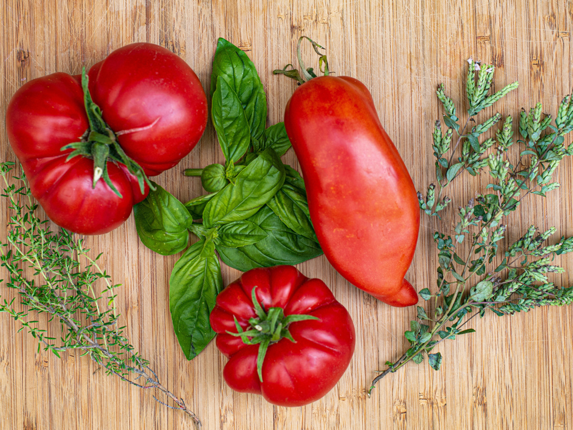 Помидоры  на разделочной доске с базиликом