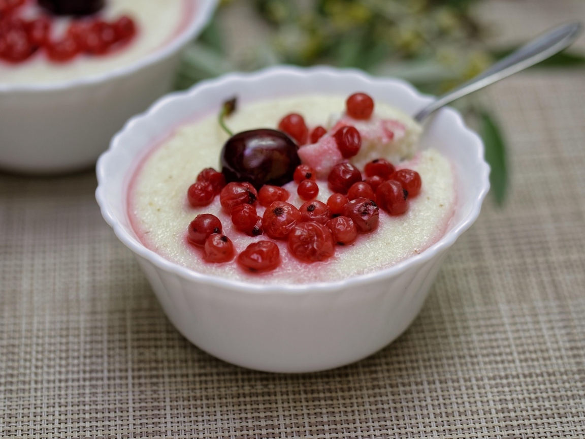 Манная каша в тарелке с ягодами