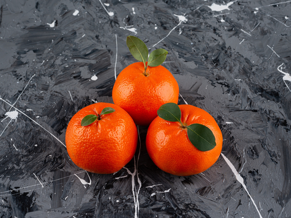 Три мандарина на сером столе