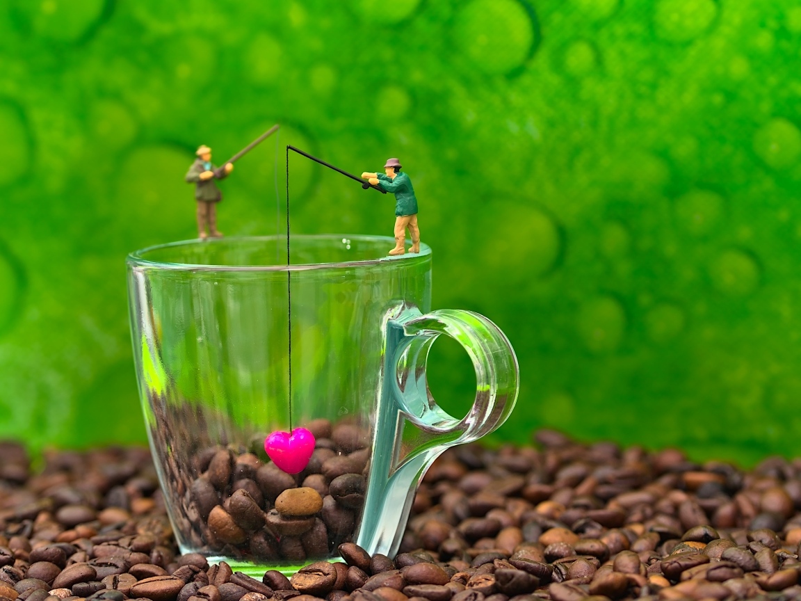 Две фигурки на стеклянной чашкой с кофейными зернами