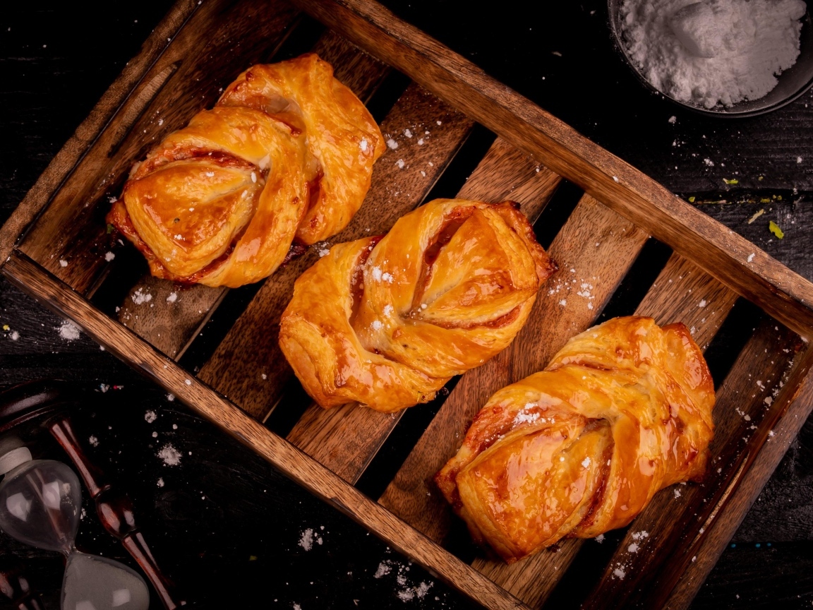 Аппетитные сладкие булочки на столе с сахарной пудрой