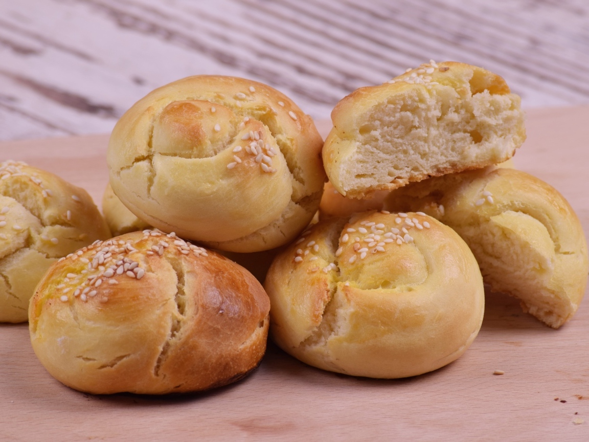 Аппетитные сладкие булочки с кунжутом на столе