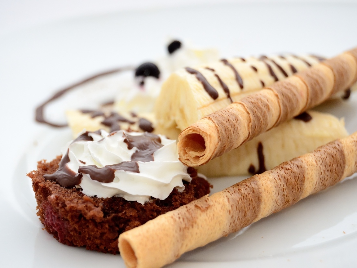 Банан на тарелке с трубочками и кексом