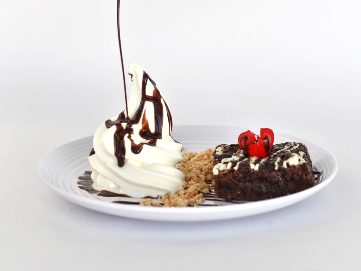 Пирожное со взбитыми сливками на тарелке на белом фоне