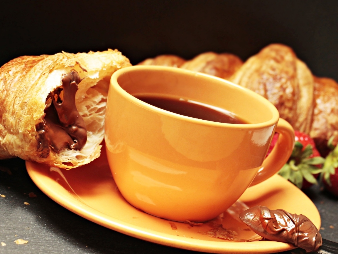 Чашка кофе на тарелке с круассанами