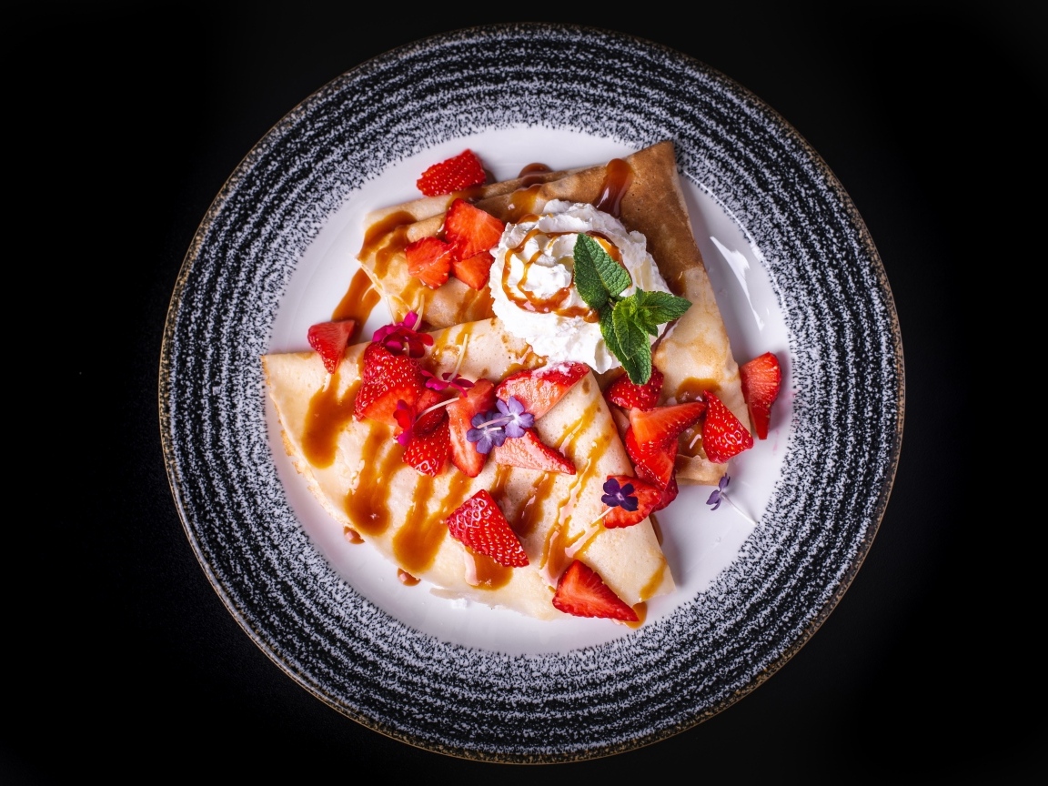 Вкусные сладкие блинчики на тарелке с ягодами