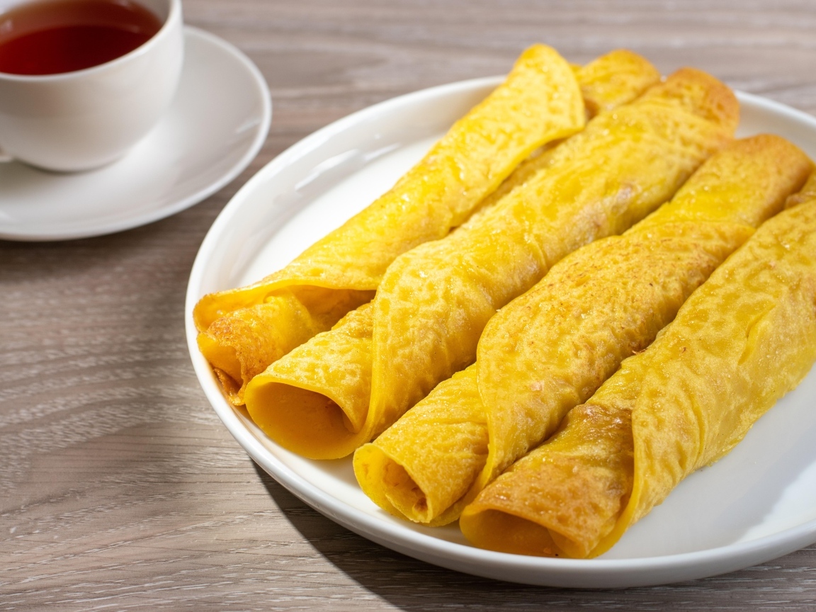 Вкусные сладкие трубочки с чаем на столе