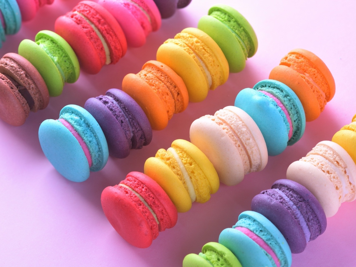 Разноцветный десерт макарун на розовом столе