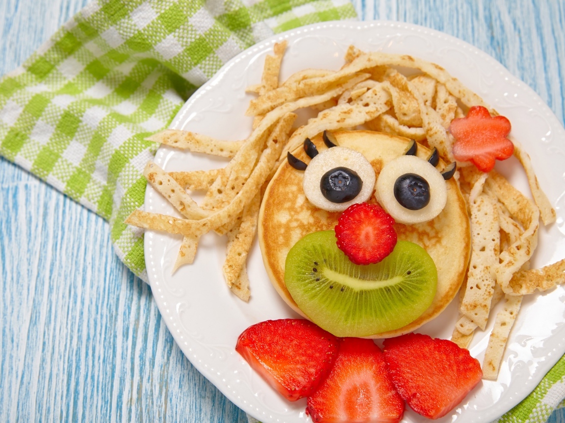 Блины с ягодами на тарелке для ребенка