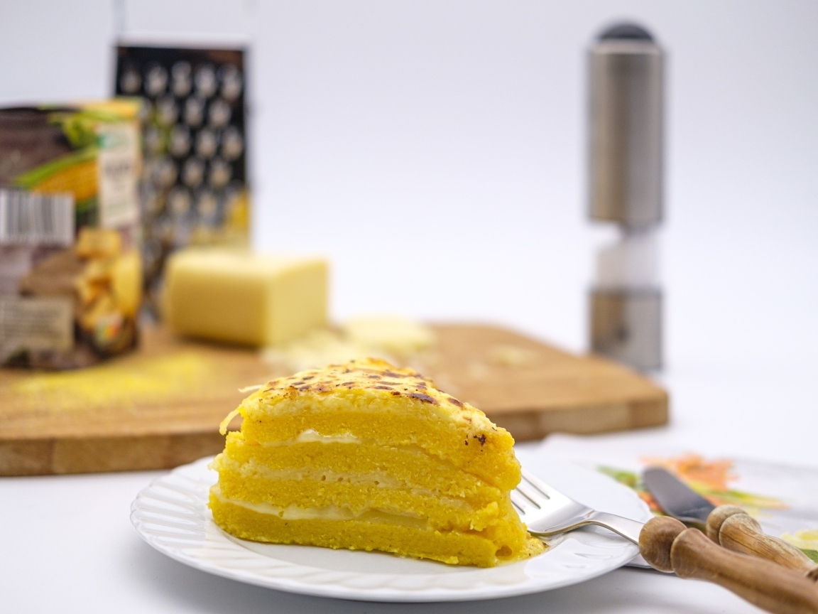 Кусок торта на столе со столовыми приборами