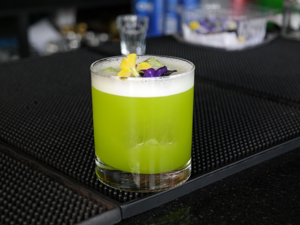 Зеленый коктейль в стакане с цветами