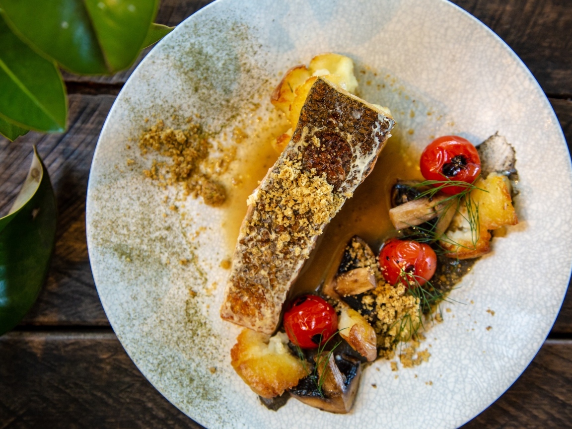 Кусок запеченной рыбы на тарелке с овощами