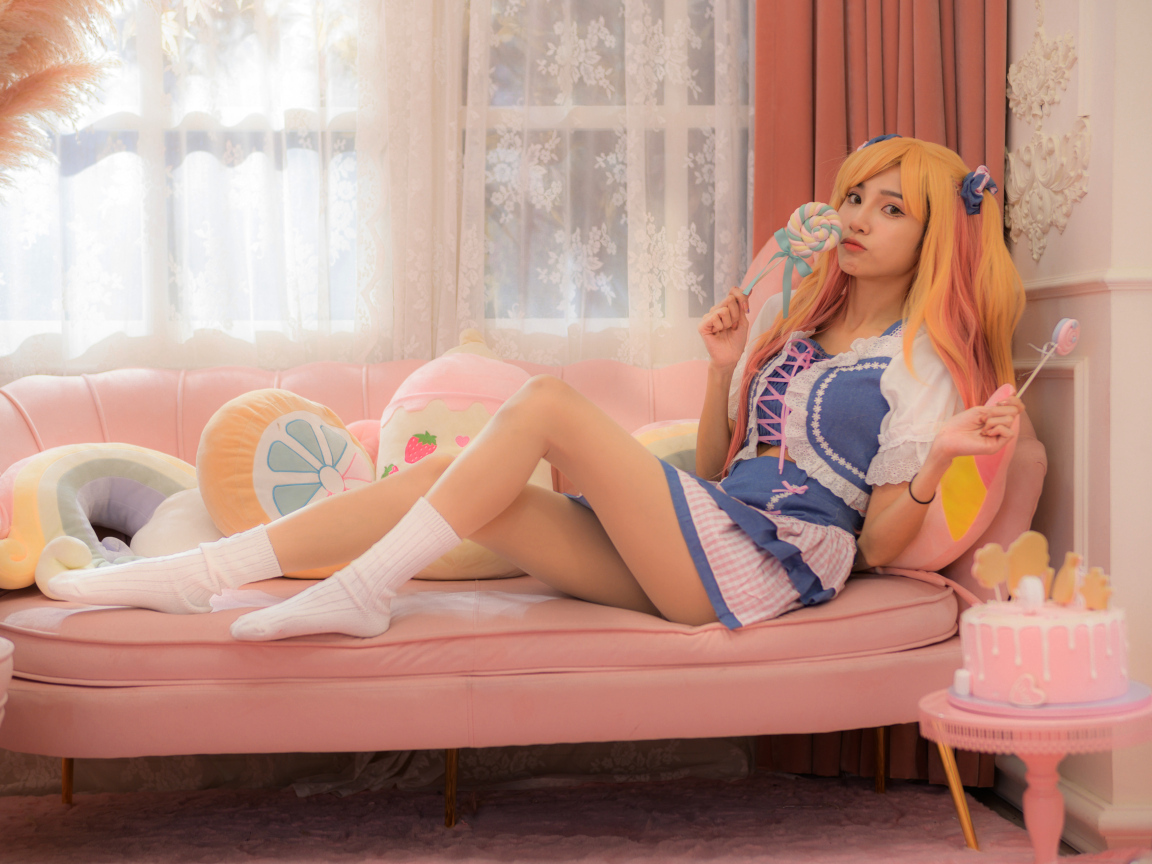 Девушка азиатка в костюме на диване 