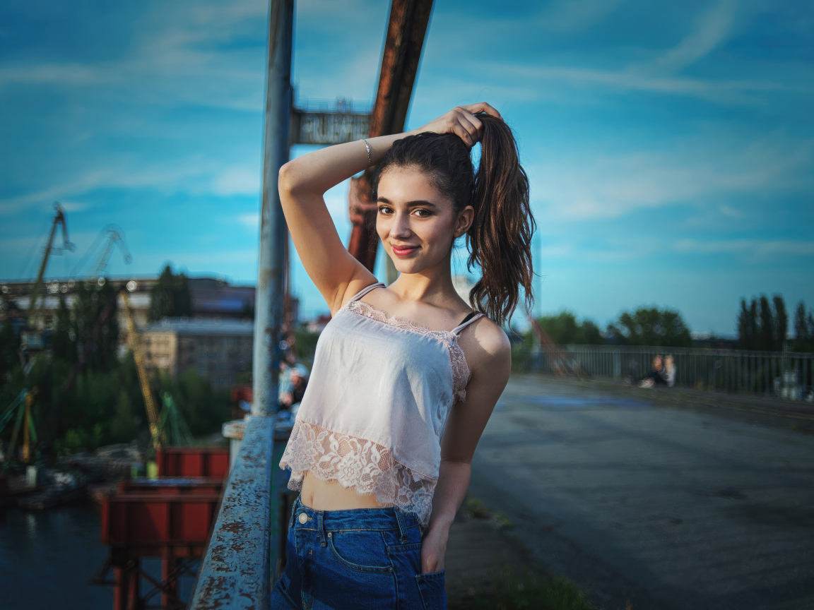 Красивая девушка держит волосы рукой