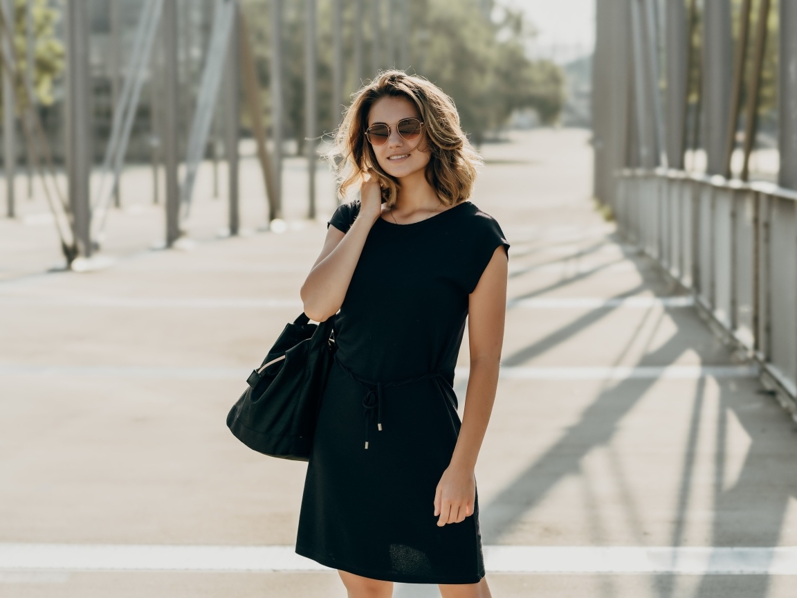 Красивая девушка в черном платье в очках